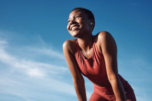 smiling young woman enjoying a beautiful day under a blue sky after learning how to stay sober after rehab