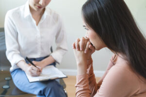 a patient listens while a therapist notes about the question posed: what is holistic therapy