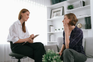 a patient talks with a therapist about aftercare program benefits