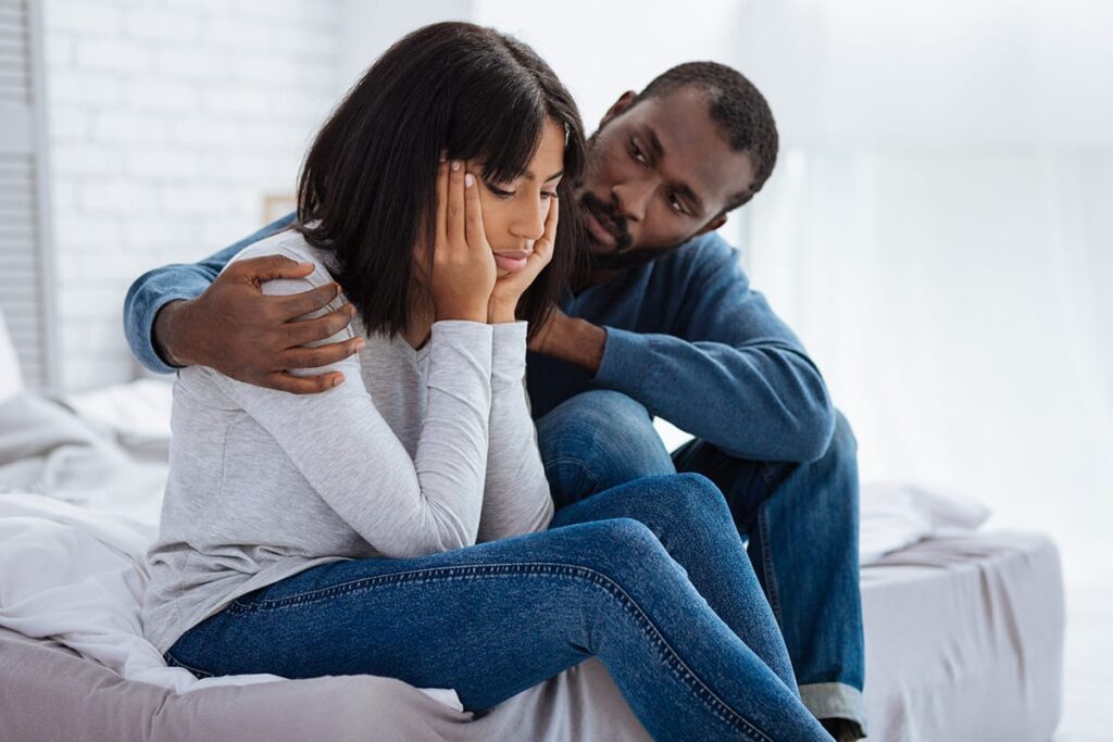 Man consoling his wife as he struggles to understand what should I do if my loved on is addicted to fentanyl
