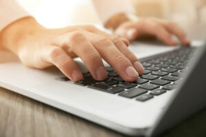 close up of a person's hands on a computer keyboard as they work at finding relapse prevention therapy in Tampa, FL