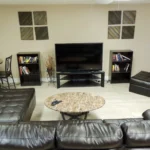 7 Summit Pathways _ Tampa, FL - living room with black leather couches