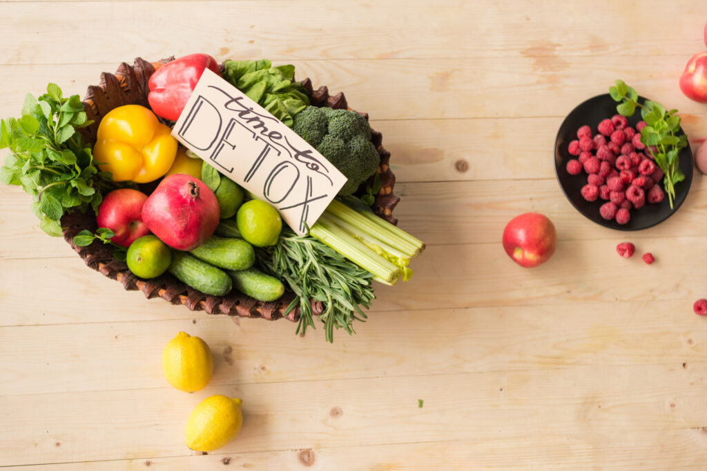 Top view of time to detox card and various healthy vegetables, fruits and berries on wooden tabletop